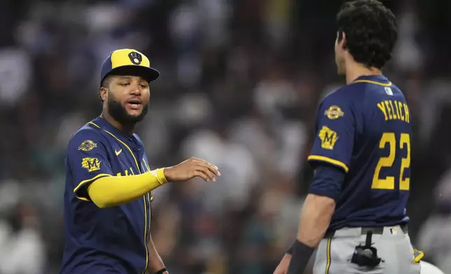 Milwaukee Brewers right fielder Jackson Chourio, facing, greets designated hitter Christian Yelich (22) as they celebrate a win against the Seattle Mariners in a baseball game Monday, July 21, 2025, in Seattle. (AP Photo/Lindsey Wasson)