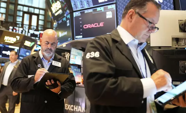 Federico DeMarco, left, and Ed Curran work on the floor at the New York Stock Exchange in New York, Wednesday, July 16, 2025. (AP Photo/Seth Wenig)