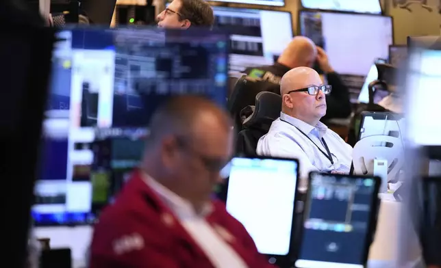 Jeffrey Vazquez works on the floor at the New York Stock Exchange in New York, Monday, July 14, 2025. (AP Photo/Seth Wenig)