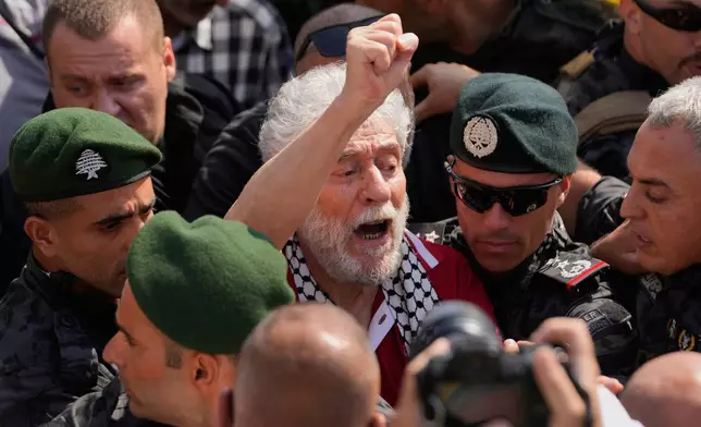 Lebanese pro-Palestinian militant Georges Abdallah, center, who was serving a life sentence for complicity in the 1982 murders of an American and an Israeli diplomat in Paris, raises his fist and chants among supporters upon his arrival at Beirut's Rafik Hariri International Airport in Beirut, Lebanon, Friday, July 25, 2025. (AP Photo/Hussein Malla)