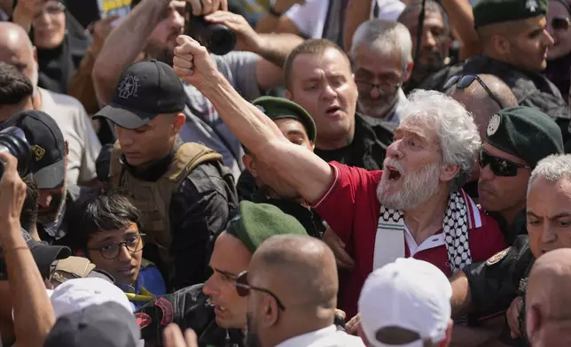 Lebanese pro-Palestinian militant Georges Abdallah, second right, who was serving a life sentence for complicity in the 1982 murders of an American and an Israeli diplomat in Paris, raises his fist and chants among supporters upon his arrival at Beirut's Rafik Hariri International Airport in Beirut, Lebanon, Friday, July 25, 2025. (AP Photo/Hussein Malla)