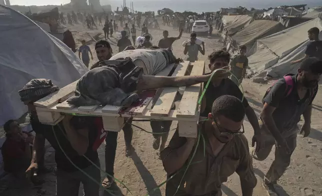CORRECTS CAUSE OF DEATH Palestinians carry the body of a man who was hit by a truck while attempting to reach a humanitarian aid convoy that entered Gaza City from the northern Gaza Strip, Saturday, July 26, 2025. (AP Photo/Jehad Alshrafi)