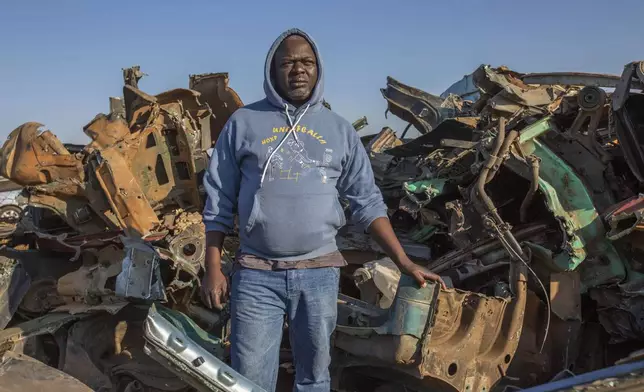 Fungai Mataga, who runs a scrap metal collection center, poses at the site in Harare, Zimbabwe, Sunday, June 8, 2025. (AP Photo/Aaron Ufumeli)