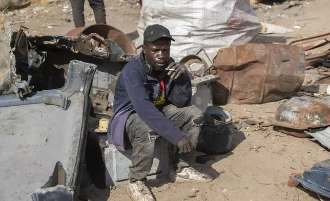 Ezekiel Mabhiza takes a break while collecting scrap metal in Harare, Zimbabwe, Sunday, June 8, 2025. (AP Photo/Aaron Ufumeli)