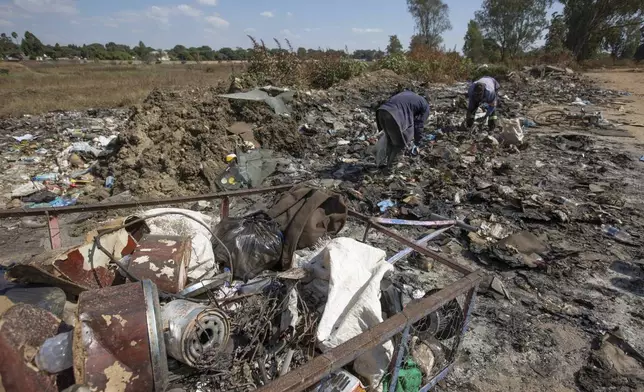 Men scrounge for scrap metal in Harare, Zimbabwe, Sunday, June 8, 2025. (AP Photo/Aaron Ufumeli)