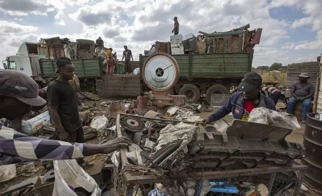 Workers load scrap metal onto a waiting truck to recycle at a collection site in Harare, Zimbabwe, Sunday, June 8, 2025. (AP Photo/Aaron Ufumeli)