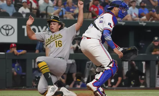 Athletics' Nick Kurtz (16) scores against Texas Rangers catcher Kyle Higashioka, right, on a single by teammate Tyler Soderstrom during the fourth inning of a baseball game, Monday, July 21, 2025, in Arlington, Texas. (AP Photo/LM Otero)