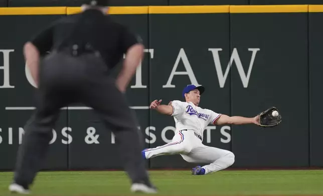 Texas Rangers left fielder Wyatt Langford catches a fly ball hit by Athletics' Luis Urías during the third inning of a baseball game, Monday, July 21, 2025, in Arlington, Texas. (AP Photo/LM Otero)