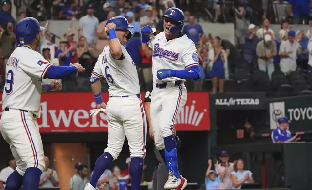 Texas Rangers' Michael Helman, right, celebrates after hitting a home run that also scored teammates Jush Jung (6) and Cody Freeman, left, during the fifth inning of a baseball game against the Athletics, Monday, July 21, 2025, in Arlington, Texas. (AP Photo/LM Otero)