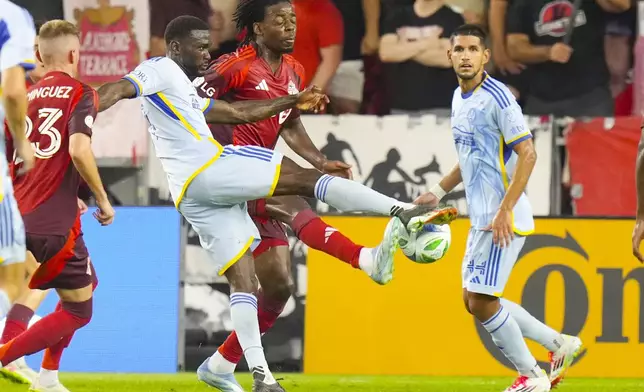 Atlanta United's Emmanuel Latte Lath, second from left, gets a shot away at the Toronto FC goal despite pressure from Deandre Kerr, second from right, during second-half MLS soccer match action in Toronto, Saturday, July 12, 2025. (Chris Young/The Canadian Press via AP)
