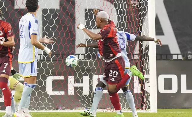 Toronto FC's Deybi Flores (20) gets in front of Atlanta United's Tristan Muyumba (8) to score his team's opening goal during second-half MLS soccer match action in Toronto, Saturday, July 12, 2025. (Chris Young/The Canadian Press via AP)
