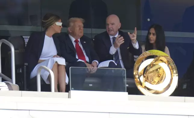 FIFA President Gianni Infantino, right, speaks with President Donald Trump and first lady Melania Trump during the Club World Cup final soccer match between Chelsea and PSG in East Rutherford, N.J., Sunday, July 13, 2025. (AP Photo/Seth Wenig)