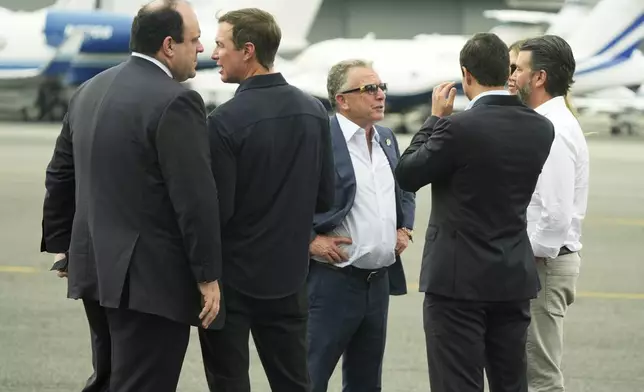 Boris Epshteyn, from left, Jared Kushner, White House special envoy Steve Witkoff, Michael Boulos, Bettina Anderson, partially obstructed and Donald Trump Jr. speak before the arrival of President Donald Trump at Teterboro Airport in Teterboro, N.J., en route to attend the Club World Cup final soccer match, Sunday, July 13, 2025. (AP Photo/Jacquelyn Martin)