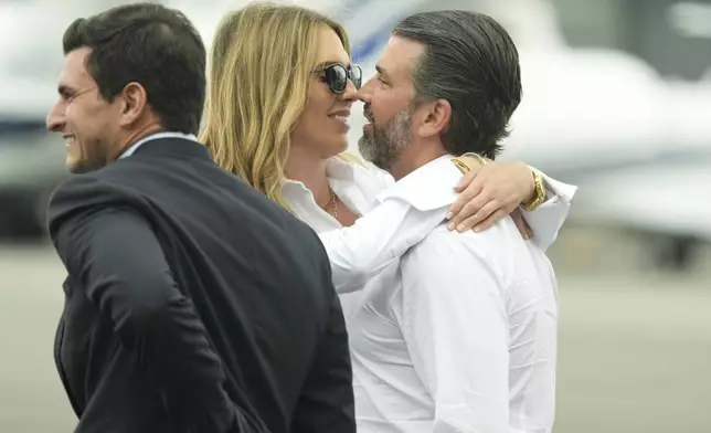 Donald Trump Jr., from right, and Bettina Anderson wait for the arrival of President Donald Trump at Teterboro Airport in Teterboro, N.J., en route to attend the Club World Cup final soccer match, Sunday, July 13, 2025. (AP Photo/Jacquelyn Martin)