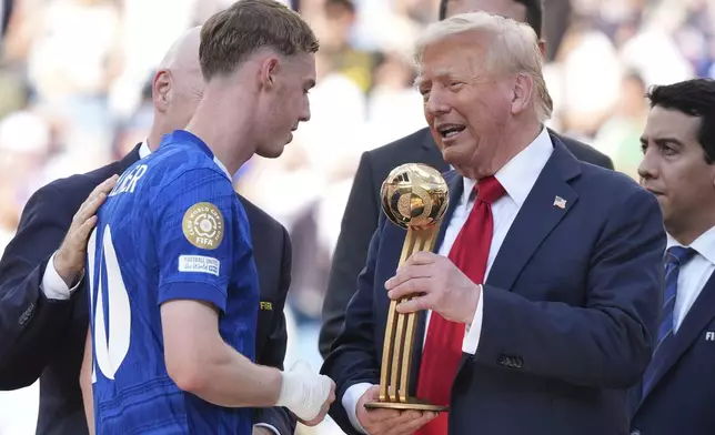 President Donald Trump, right, presents the Golden Ball award to Chelsea's Cole Palmer at the Club World Cup final soccer match between Chelsea and PSG at MetLife Stadium in East Rutherford, N.J., Sunday, July 13, 2025. (AP Photo/Jacquelyn Martin)