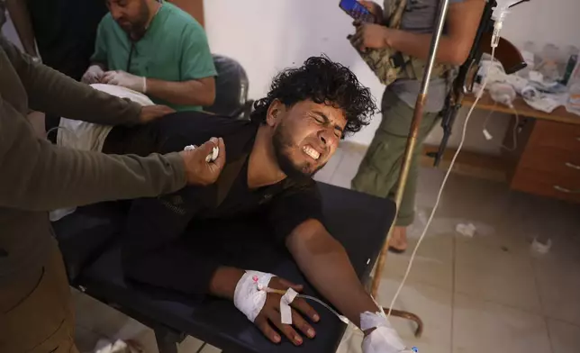 A Syrian government soldier who was injured in Sweida city during clashes between the Syrian government forces and Druze militias, gets treated at a clinic in Busra al-Harir village, in southern Syria, Tuesday, July 15, 2025. (AP Photo/Omar Albam)