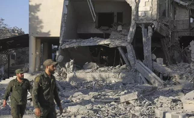 Soldiers inspect the damaged Syrian Defense Ministry building allegedly hit by several Israeli airstrikes, in Damascus, Syria, Wednesday, July 16, 2025. (AP Photo/Ghaith Alsayed)
