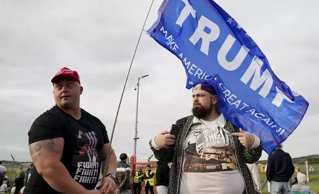 People gather outside the airport in Prestwick, South Ayrshire, Scotland, on Friday, July 25, 2025, ahead of the arrival of U.S. President Donald Trump. (Jane Barlow/PA via AP)