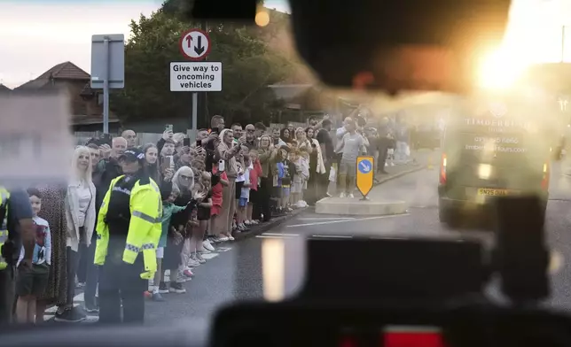 Onlookers take pictures as the convoy with President Donald Trump passes by in Turnberry, Scotland, Friday, July 25, 2025.(AP Photo/Jacquelyn Martin)