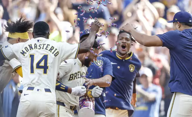 Milwaukee Brewers' Jackson Chourio, middle, is congratulated by teammates after his game-winning single during the 10th inning of a baseball game against the Los Angeles Dodgers, Wednesday, July 9 2025, in Milwaukee. (AP Photo/Jeffrey Phelps)