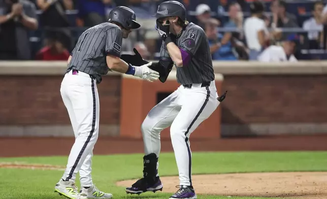 New York Mets' Brett Baty, right, greets teammate Jeff McNeil after a two-run home run during the fourth inning of a baseball game against the Los Angeles Angels, Monday, July 21, 2025, in New York. (AP Photo/Heather Khalifa)