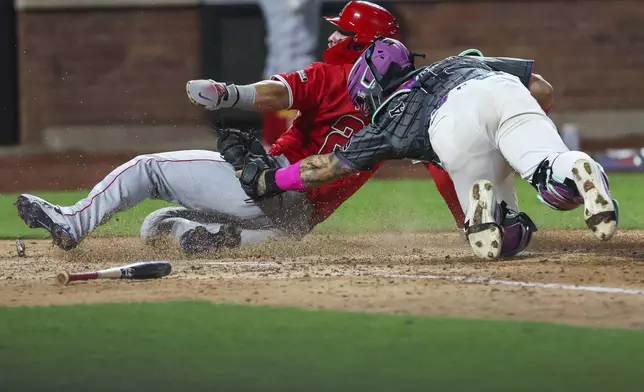 Los Angeles Angels' Mike Trout, left, is tagged out at home plate by New York Mets catcher Francisco Alvarez, right, during the seventh inning of a baseball game, Monday, July 21, 2025, in New York. (AP Photo/Heather Khalifa)