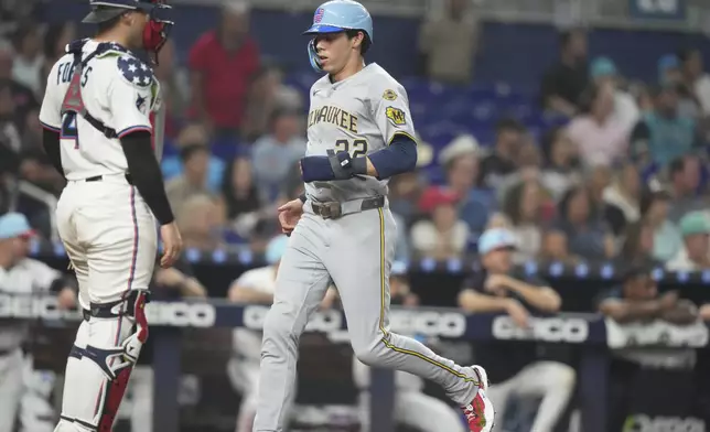Milwaukee Brewers' Christian Yelich (22) scores on a double hit by Jackson Chourio during the eighth inning of a baseball game against the Miami Marlins, Friday, July 4, 2025, in Miami. (AP Photo/Lynne Sladky)