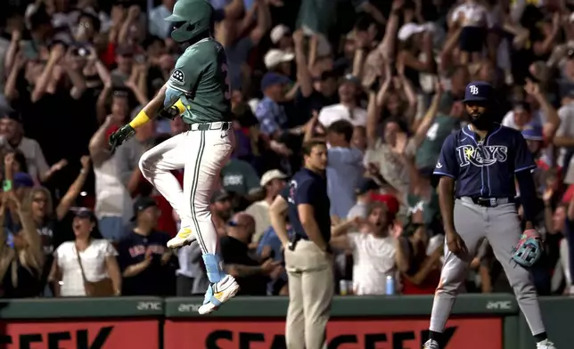 Boston Red Sox's Ceddanne Rafaela, left, reacts after hitting a two-run walkoff home run during the ninth inning of a baseball game against the Tampa Bay Rays, Friday, July 11, 2025, in Boston. (AP Photo/Mark Stockwell)