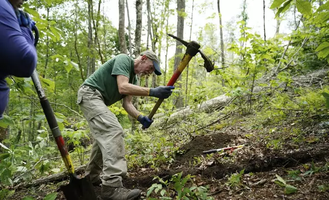 Volunteer Laura Elliot, left, looks on as Matt Perrenod, crew leader for the Appalachian Trail Conservancy, digs a privy hole near the Cherry Gap Shelter along the Appalachian Trail during a trail rebuilding project, July 22, 2025, in Unicoi, Tenn. (AP Photo/Erik Verduzco)