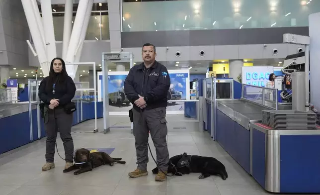 Chilean security agents stand with their sniffer dogs during a a security demonstration related to TSA screening and a Biometric Identification Transnational Migration Alert Program (BITMAP) at the Arturo Merino BenÌtez International Airport, Wednesday, July 30, 2025, in Santiago, Chile, before the departure of U.S. Homeland Security Secretary Kristi Noem. (AP Photo/Alex Brandon, Pool)