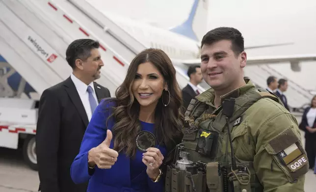 U.S. Homeland Security Secretary Kristi Noem poses for photos with a member of the Chilean special operations police (GOPE) as she departs Arturo Merino Benitez International Airport in Santiago, Chile, Wednesday, July 30, 2025. (AP Photo/Alex Brandon, Pool)