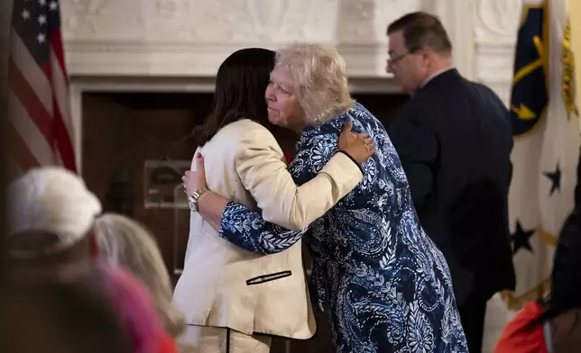 Rhode Island Senate President Valarie J. Lawson, right, hugs Rhode Island Lt. Gov. Sabina Matos before Gov. Dan McKee signs a bill banning the sale of assault-style weapons in the state of Rhode Island at the Rhode Island Statehouse in Providence, Thursday, June 26, 2025. (AP Photo/Sydney Roth)