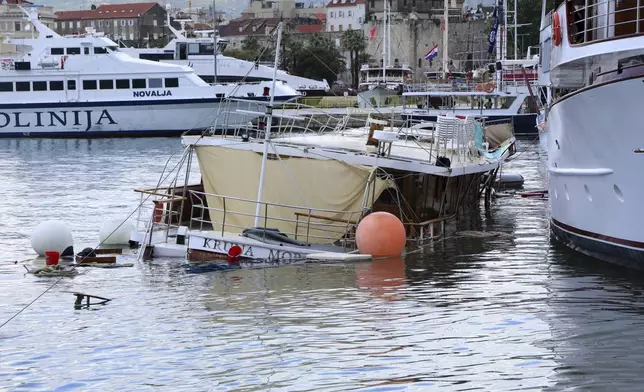 A boat looks submerged in the harbor in Split, Croatia, Tuesday, July 8, 2025, following a powerful storm. (AP Photo/Tom Dubravec)
