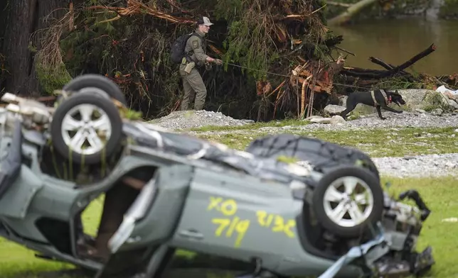 Officials comb through the banks of the Guadalupe River after a flash flood swept through the area Saturday, July 5, 2025, in Hunt, Texas. (AP Photo/Julio Cortez)