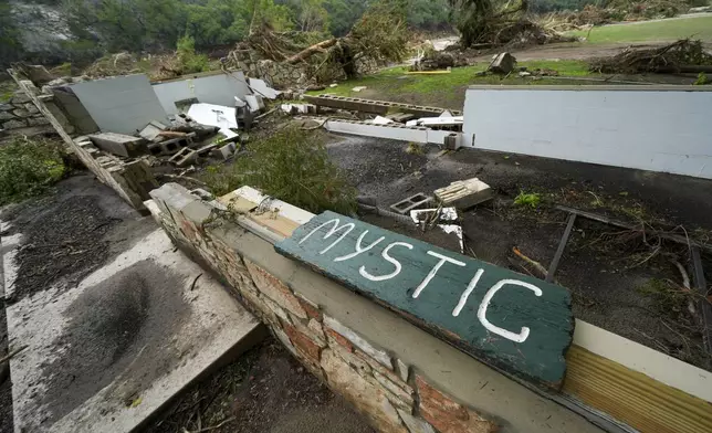 A Camp Mystic sign is seen near the entrance to the establishment along the banks of the Guadalupe River after a flash flood swept through the area in Hunt, Texas, Saturday, July 5, 2025. (AP Photo/Julio Cortez)