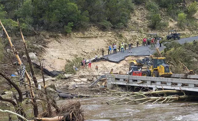 Crews work to clear debris from the Cade Loop bridge along the Guadalupe River on Saturday, July 5, 2025, in Ingram, Texas. (AP Photo/Rodolfo Gonzalez)