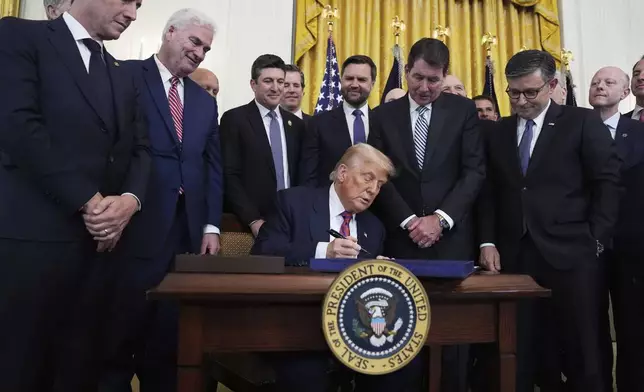 President Donald Trump signs the GENIUS Act, a bill that regulates stablecoins, a type of cryptocurrency, in the East Room of the White House, Friday, July 18, 2025, in Washington. (AP Photo/Evan Vucci)