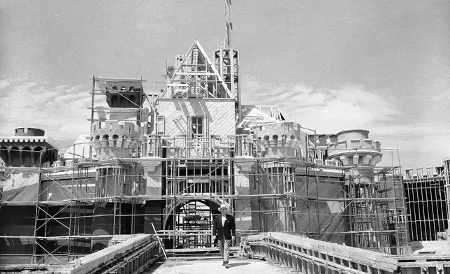 FILE - Walt Disney crosses the drawbridge that serves as the entrance to Sleeping Beauty Castle at Disneyland, in Anaheim, Calif., on April 16, 1955. (AP Photo/David F. Smith, File)