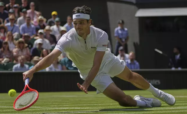 Taylor Fritz of the U.S. dives to return to Alejandro Davidovich Fokina of Spain during a third round singles match at the Wimbledon Tennis Championships in London, Friday, July 4, 2025. (AP Photo/Kin Cheung)
