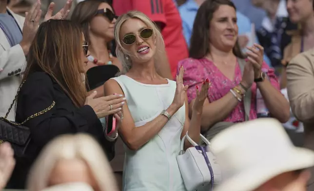 Morgan Riddle, center, the girlfriend of Taylor Fritz of the U.S. applauds after he beat Alejandro Davidovich Fokina of Spain in a third round singles match at the Wimbledon Tennis Championships in London, Friday, July 4, 2025. (AP Photo/Kin Cheung)