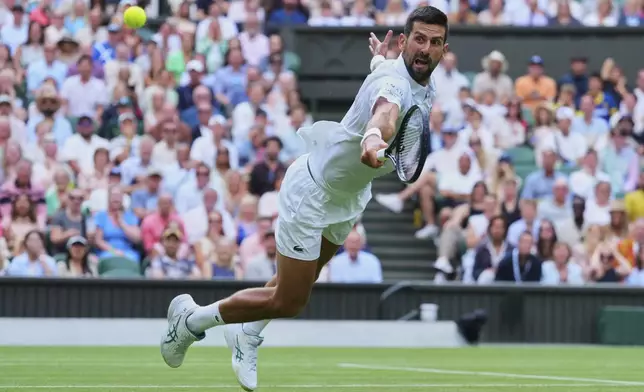 Novak Djokovic of Serbia dives to return to Miomir Kecmanovic of Serbia during a third round men's singles match at the Wimbledon Tennis Championships in London, Saturday, July 5, 2025. (AP Photo/Kirsty Wigglesworth)