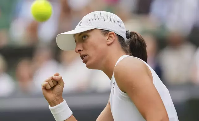 Iga Swiatek of Poland celebrates after winning a point against Danielle Collins of the U.S. during a third round women's singles match at the Wimbledon Tennis Championships in London, Saturday, July 5, 2025. (AP Photo/Kirsty Wigglesworth)
