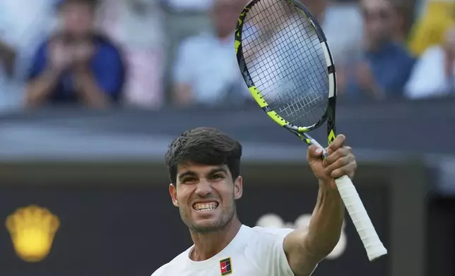 Carlos Alcaraz of Spain celebrates after beating Jan-Lennard Struff of Germany during a third round men's singles match at the Wimbledon Tennis Championships in London, Friday, July 4, 2025. (AP Photo/Kin Cheung)