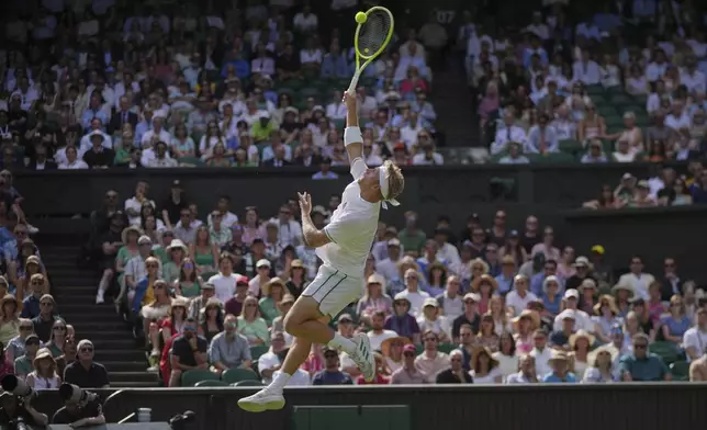 Alejandro Davidovich Fokina of Spain smashes the ball to win a point against Taylor Fritz of the U.S. during a third round singles match at the Wimbledon Tennis Championships in London, Friday, July 4, 2025. (AP Photo/Kin Cheung)