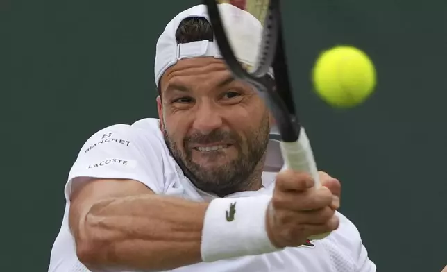 Grigor Dimitrov of Bulgaria returns to Sebastian Ofner of Austria during a third round men's singles match at the Wimbledon Tennis Championships in London, Saturday, July 5, 2025. (AP Photo/Joanna Chan)