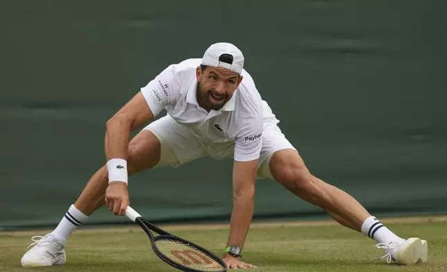 Grigor Dimitrov of Bulgaria slips after returning to Sebastian Ofner of Austria during a third round men's singles match at the Wimbledon Tennis Championships in London, Saturday, July 5, 2025. (AP Photo/Joanna Chan)