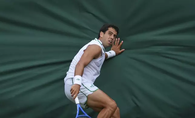 Jaume Munar of Spain touches the back wall of the court after returning to Marin Cilic of Croatia during a third round men's singles match at the Wimbledon Tennis Championships in London, Saturday, July 5, 2025. (AP Photo/Joanna Chan)