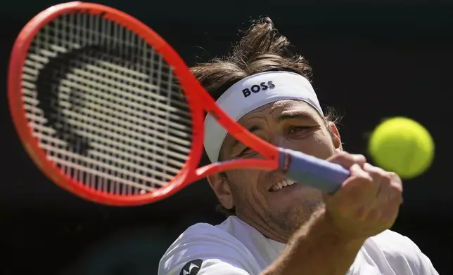 Taylor Fritz of the U.S. returns to Alejandro Davidovich Fokina of Spain during a third round singles match at the Wimbledon Tennis Championships in London, Friday, July 4, 2025. (AP Photo/Kin Cheung)