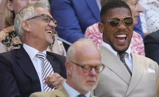 Broadcaster and former soccer player Gary Lineker, left, and boxer Anthony Joshua arrive in the Royal Box on day five at the Wimbledon Tennis Championships in London, Friday, July 4, 2025. (AP Photo/Kin Cheung)