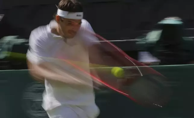 Taylor Fritz of the U.S. returns to Alejandro Davidovich Fokina of Spain during a third round singles match at the Wimbledon Tennis Championships in London, Friday, July 4, 2025. (AP Photo/Kin Cheung)